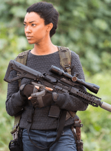 Sonequa Martin-Green as Sasha Williams in The Walking Dead, holding a gun with natural hair