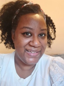 Picture of author smiling with natural hair in a twist out hairstyle